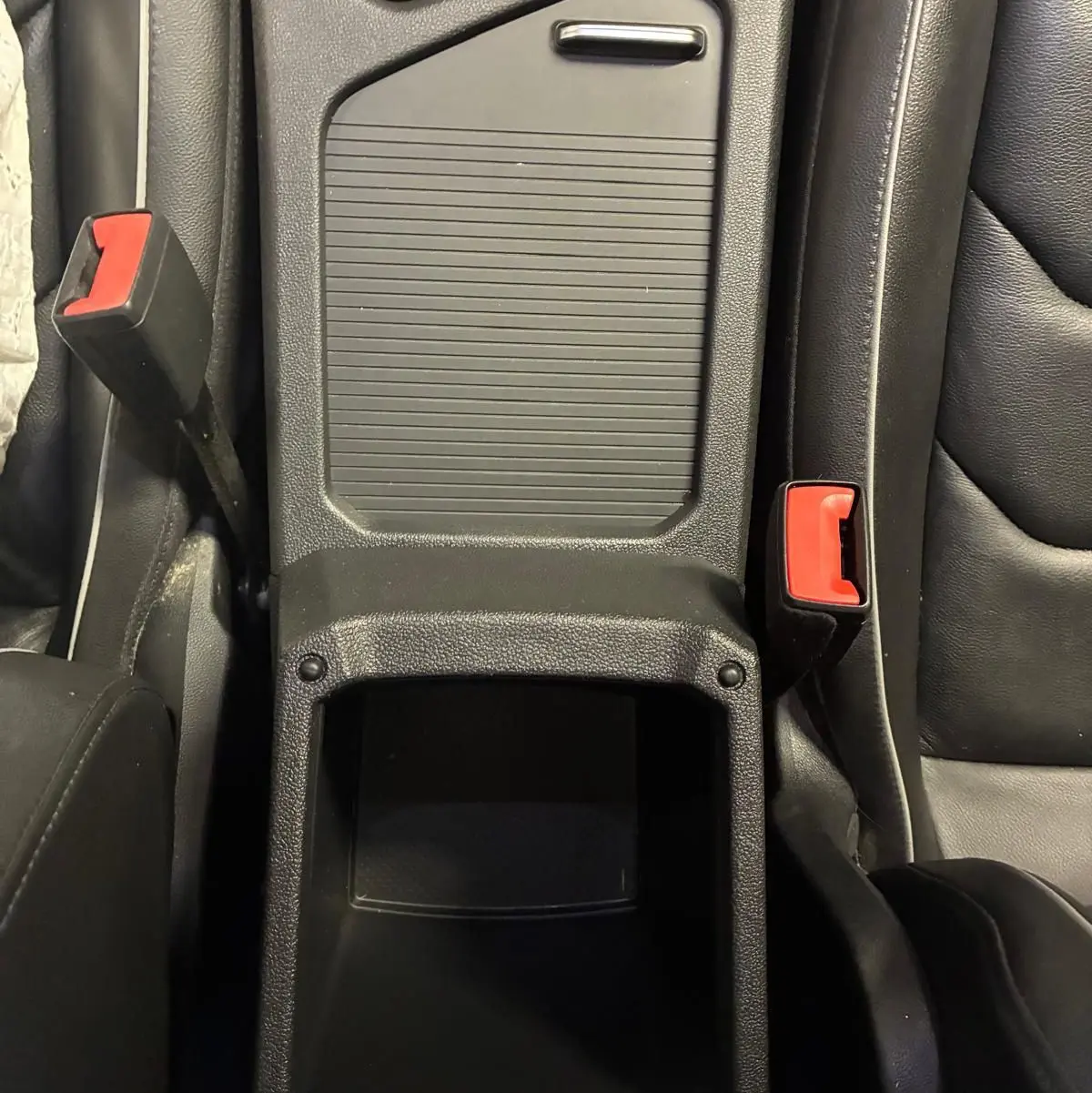 Vue plongeante sur la console centrale noire en cuir du Volkswagen Tiguan 2.0 TDI avec boutons et espace de rangement.