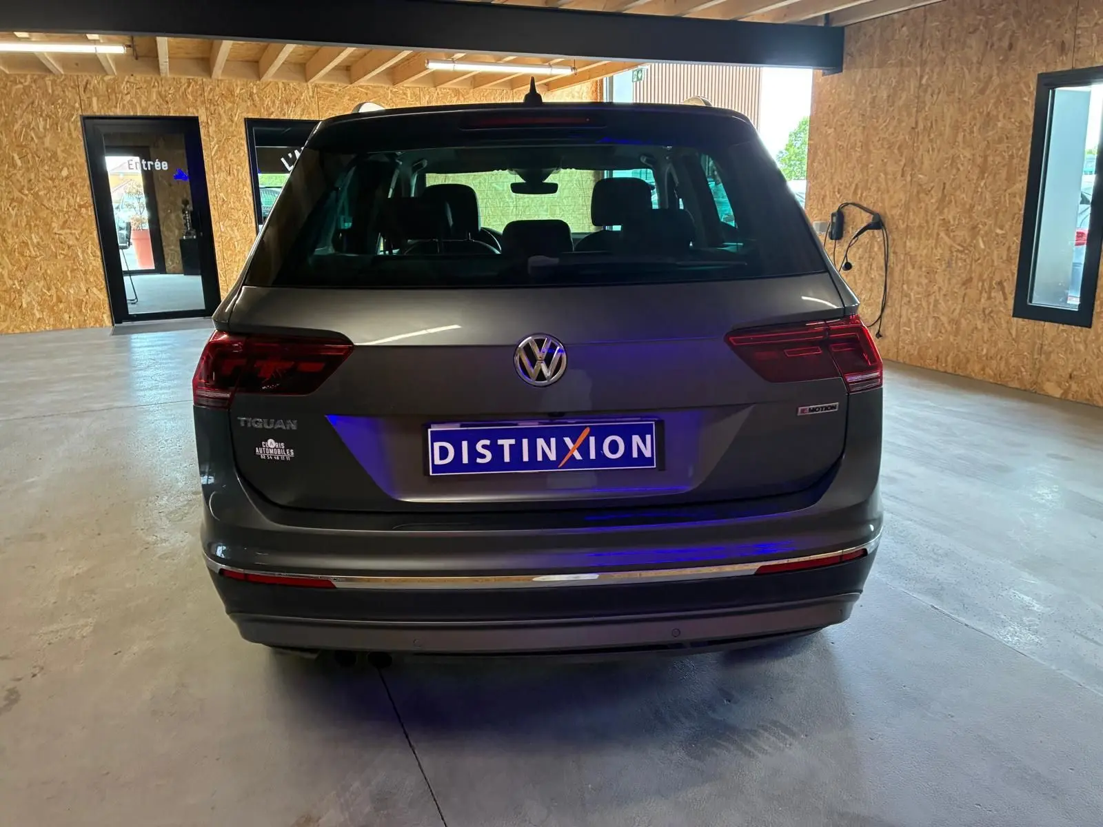Vue arrière d'un Volkswagen Tiguan gris 2020 avec logo 4MOTION dans un garage lumineux.