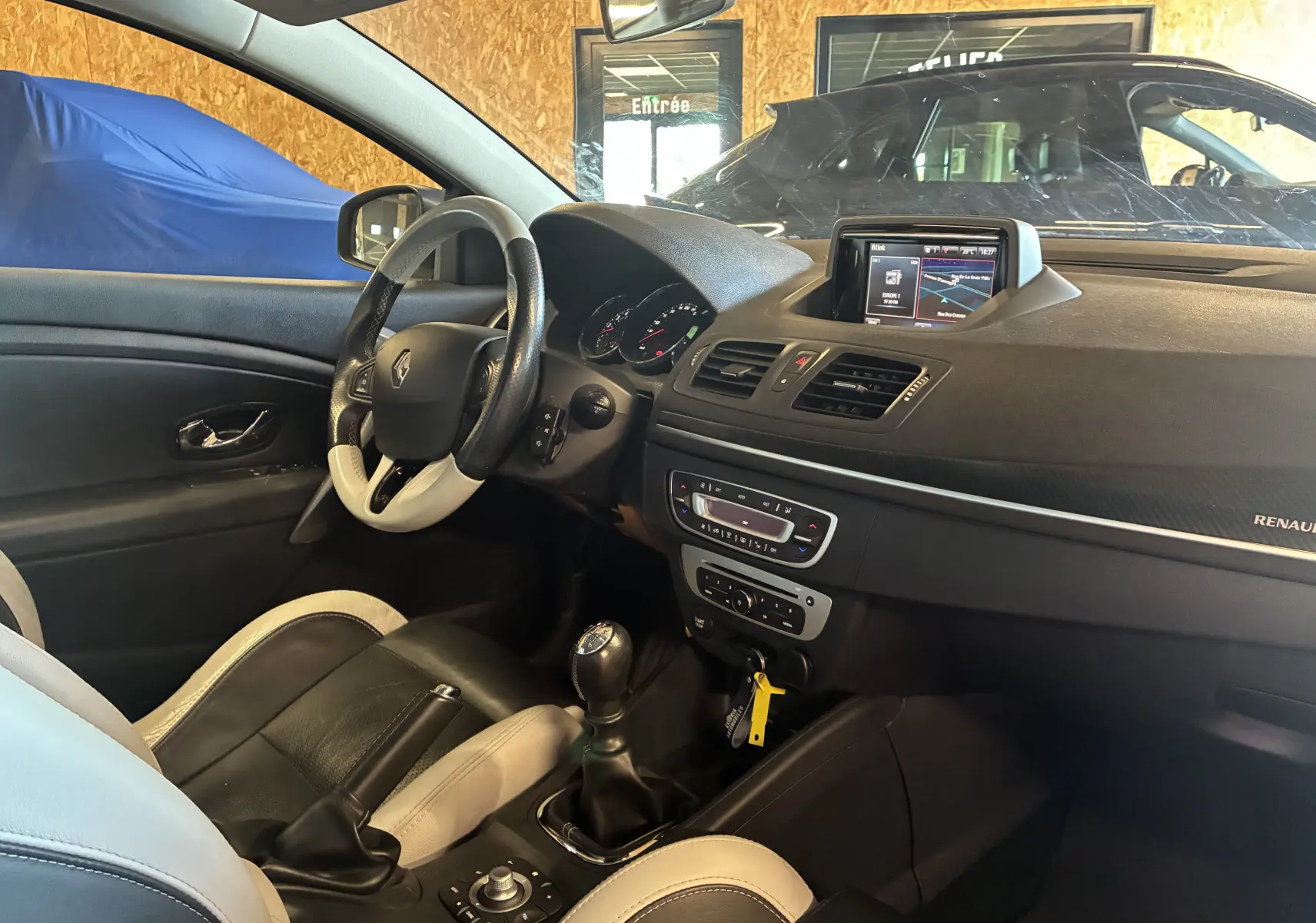 Vue intérieure côté conducteur de la Renault Mégane Coupé 2.0 DCI 165 GT 2014, volant cuir bicolore et écran tactile 7 pouces.
