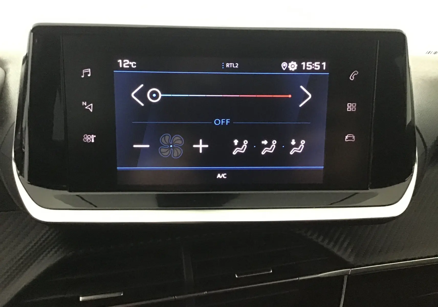 Écran tactile central de la Peugeot 208 2022 affichant les réglages de climatisation avec interface moderne noire.