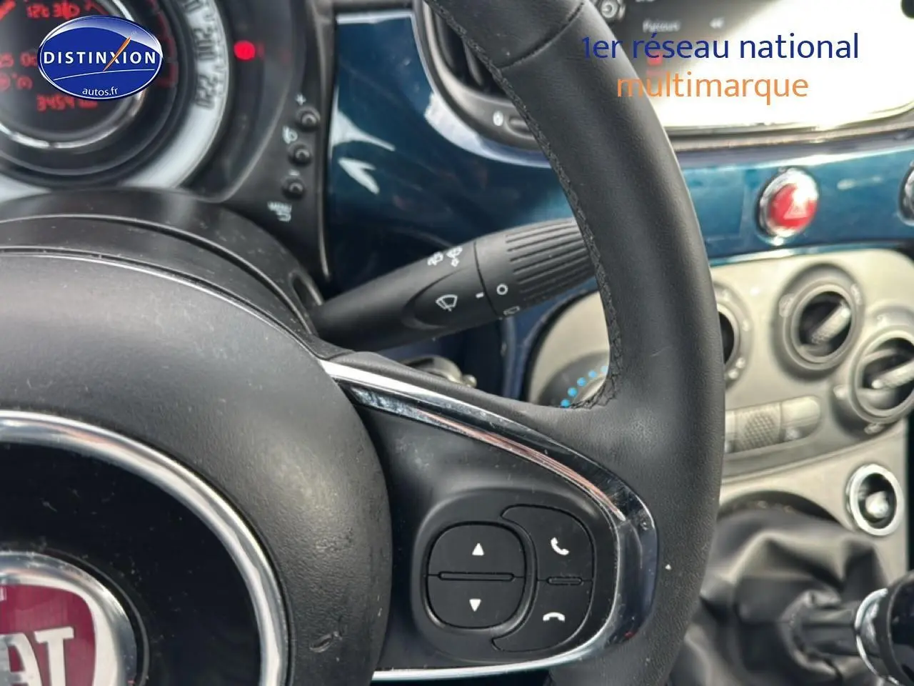 Gros plan sur le volant cuir multifonction et tableau de bord bleu foncé de la Fiat 500 1.0 70 bsg cult 2023.