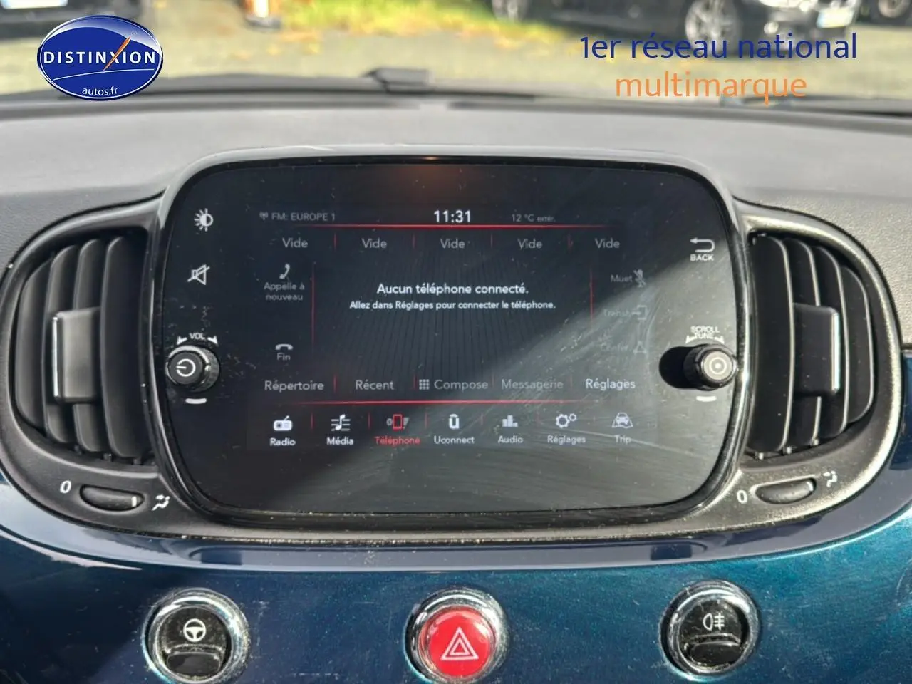 Gros plan sur l'écran tactile central et la console bleue foncée de la Fiat 500 1.0 70 bsg cult 2023.