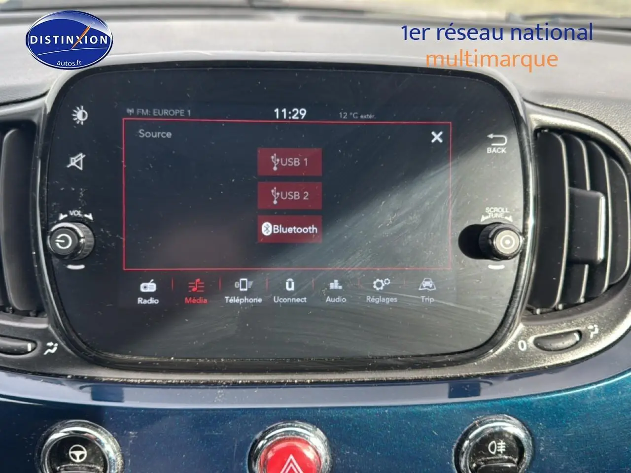 Écran tactile central de la Fiat 500 bleu foncé, vue rapprochée du tableau de bord avec commandes multimédia.