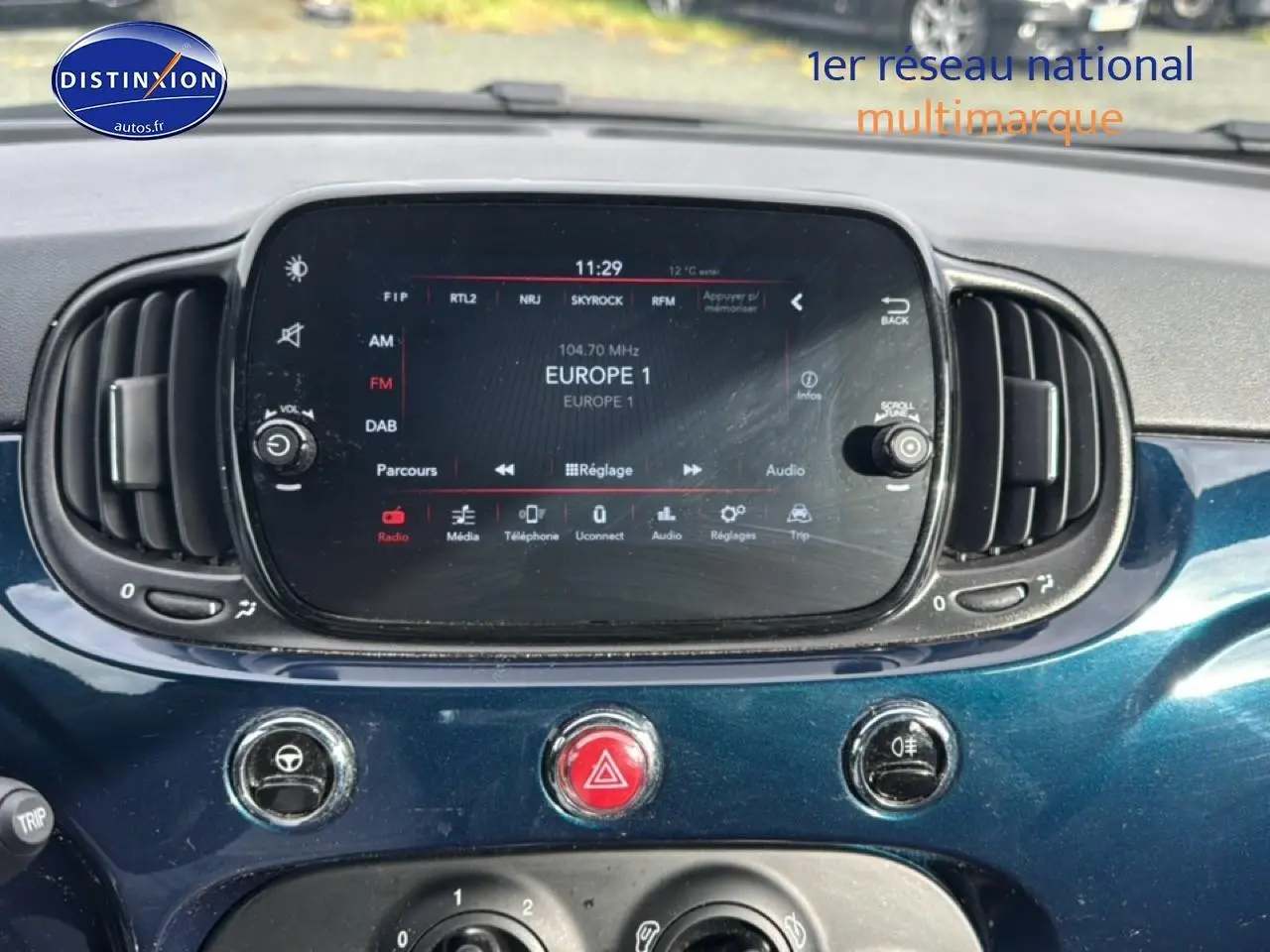 Vue rapprochée du tableau de bord bleu foncé de la Fiat 500 2023 avec écran tactile et commandes centrales.