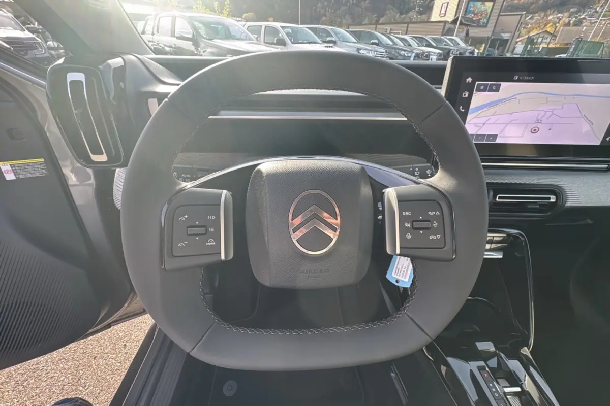 Volant cuir multifonctions de la Citroën C3 Aircross Hybrid 145, avec tableau de bord numérique et écran tactile GPS.