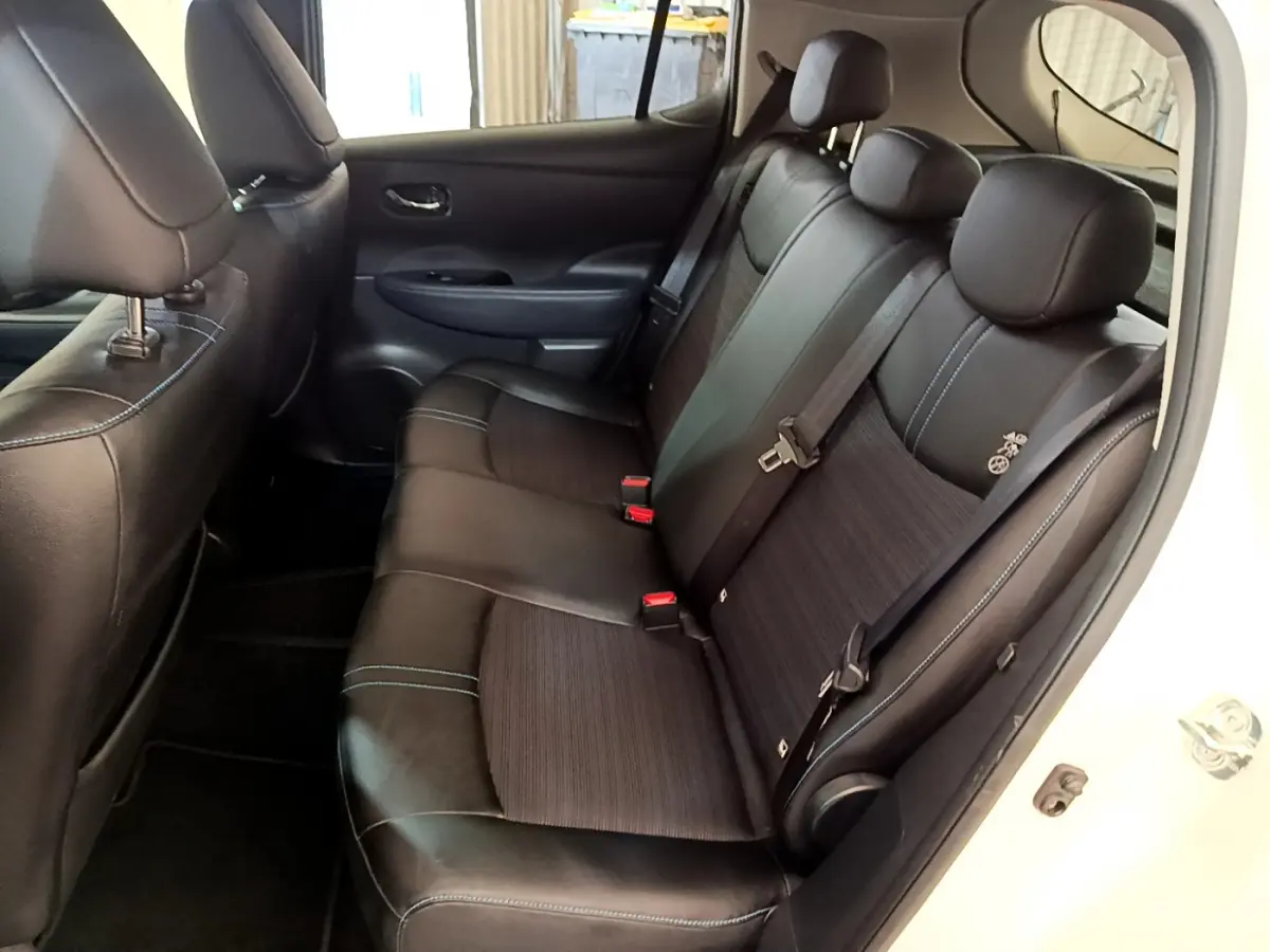 Vue intérieure côté droit sur la banquette arrière noire avec surpiqûres bleues du Nissan Leaf blanc 2020 Business+.