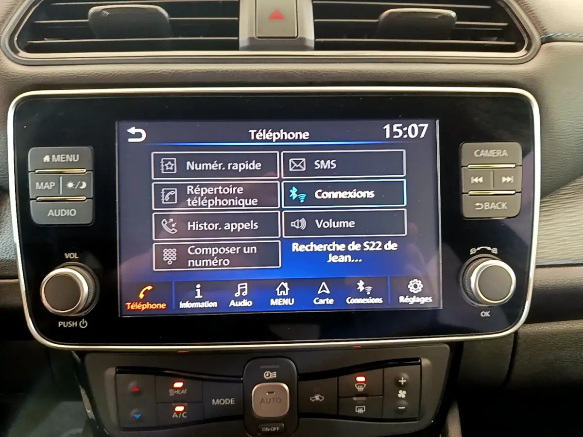 Écran tactile central du tableau de bord noir de la Nissan Leaf blanche, affichant le menu téléphone à 15h07.