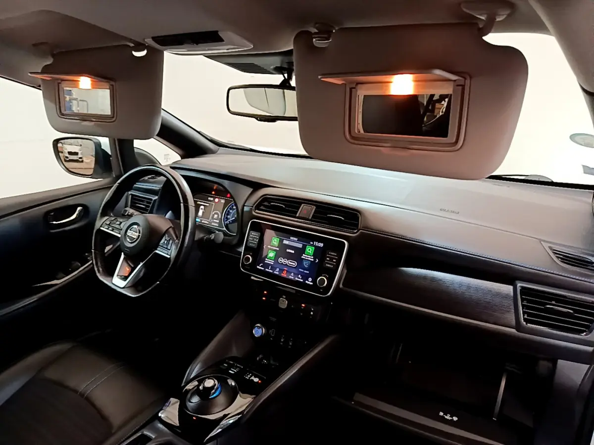 Intérieur noir de la Nissan Leaf 62 kWh 2020 vu côté conducteur, avec tableau de bord et écran tactile allumé.