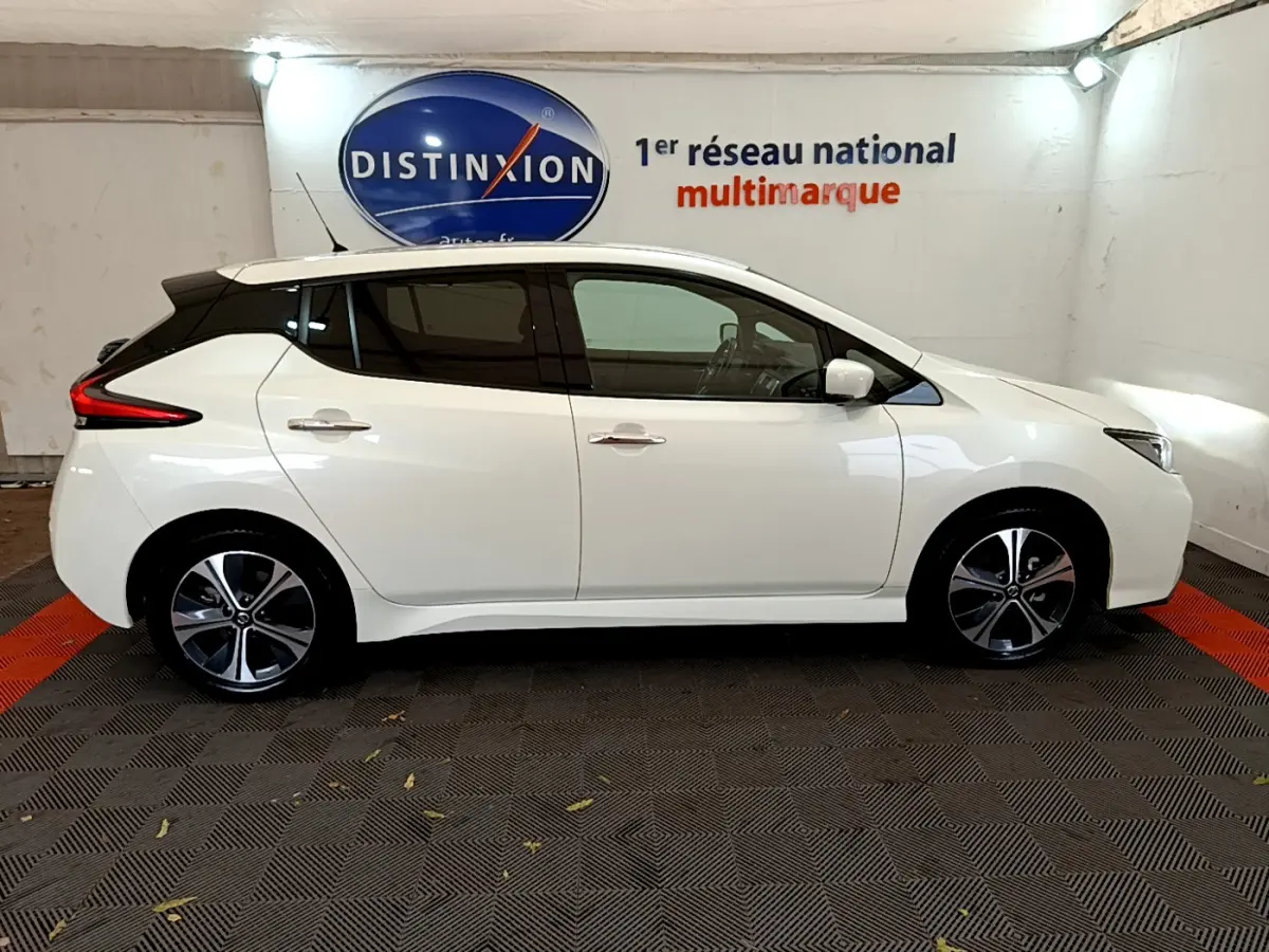 Profil latéral droit d'une Nissan Leaf blanche 2020 électrique, avec jantes alliage et vitres teintées.