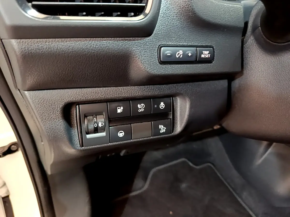 Gros plan sur les commandes noires du tableau de bord côté conducteur d'une Nissan Leaf blanche 2020.