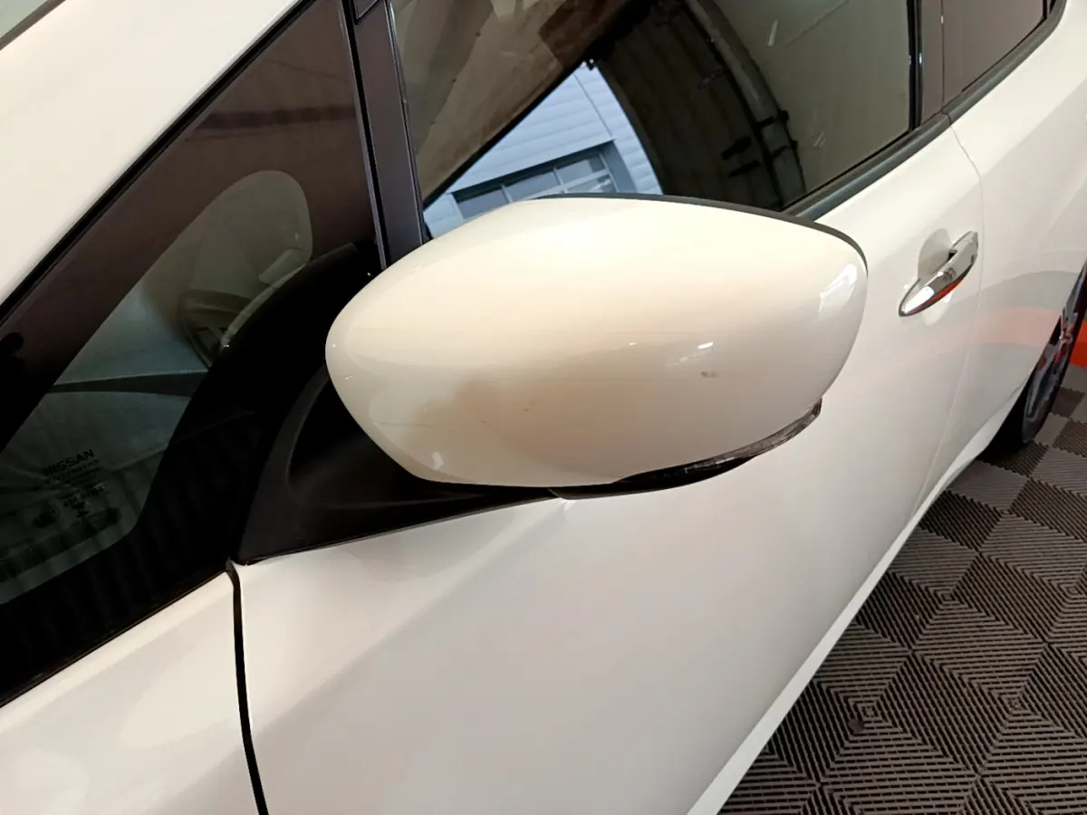Rétroviseur côté gauche blanc sur Nissan Leaf 62 kWh 2020 avec poignée de porte chromée visible.