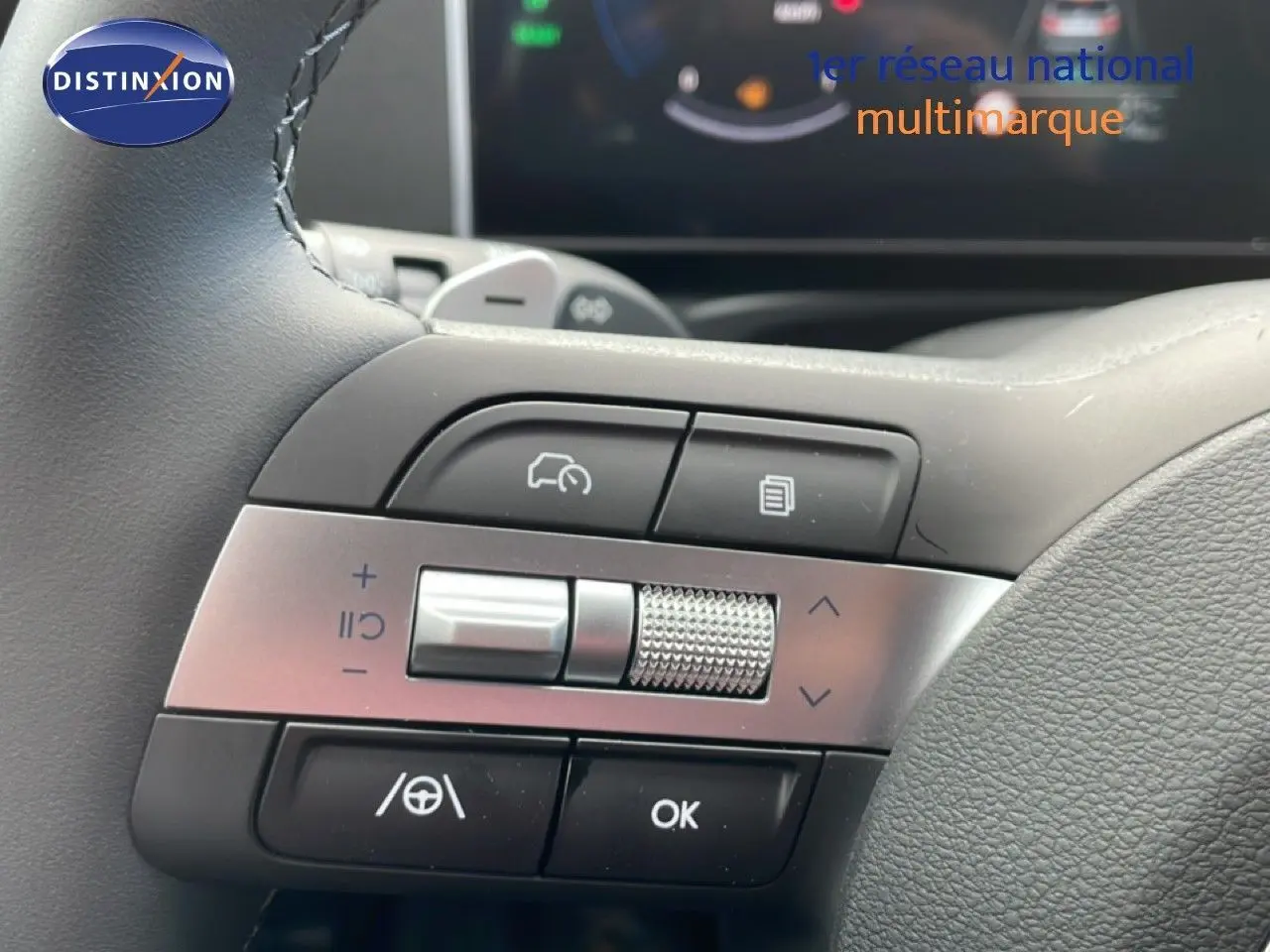 Gros plan sur les commandes multifonctions à gauche du volant du Hyundai Tucson blanc, avec molette et boutons tactiles.