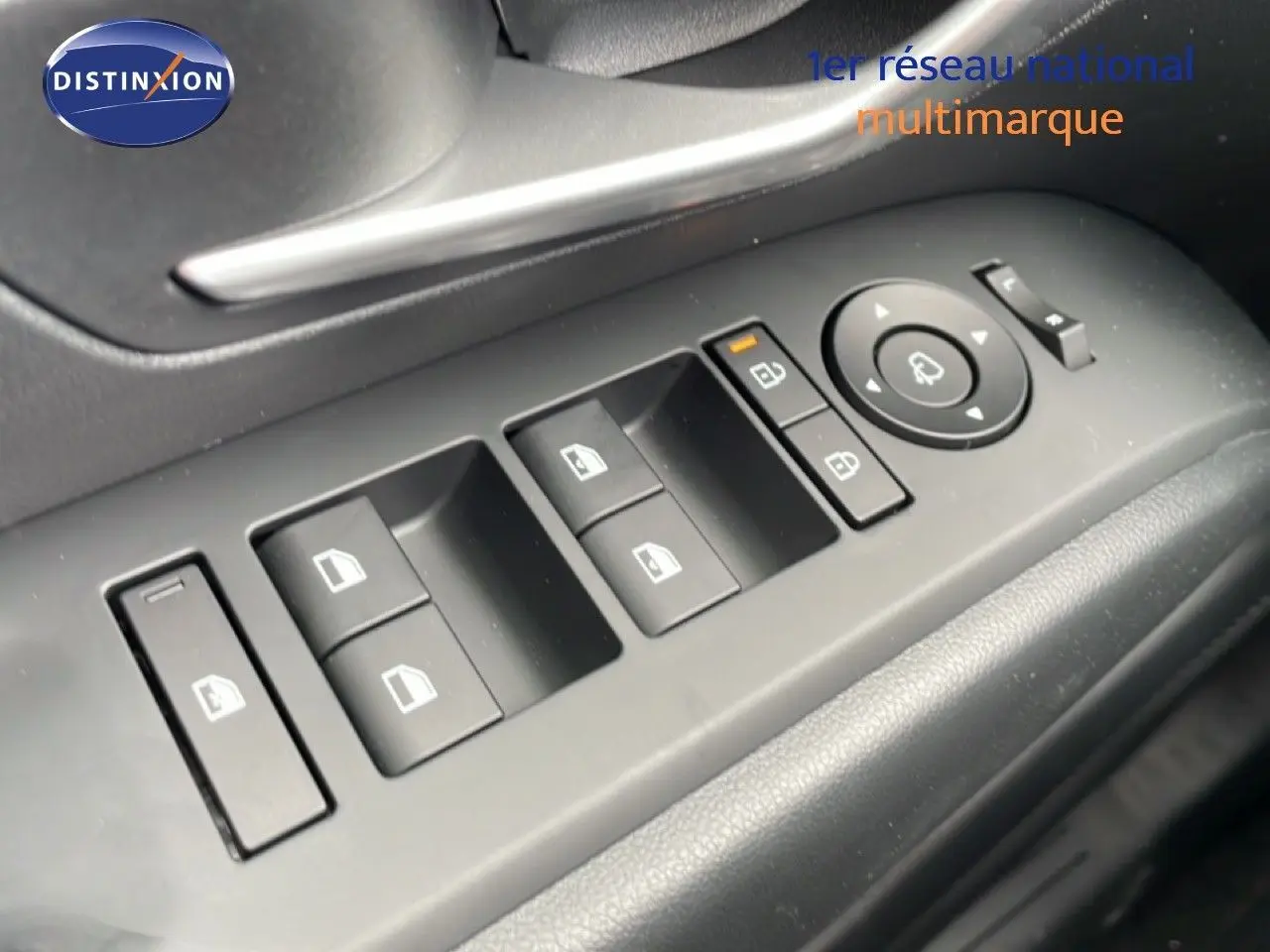 Gros plan sur les commandes des vitres et rétroviseurs côté conducteur d’un Hyundai Tucson blanc Atlas 2026.