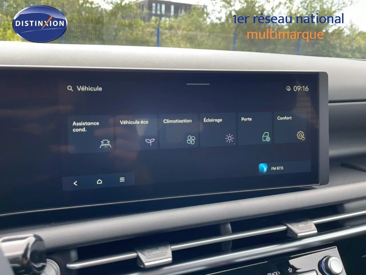 Écran tactile central du tableau de bord du Hyundai Tucson blanc, affichant les réglages du véhicule en intérieur.
