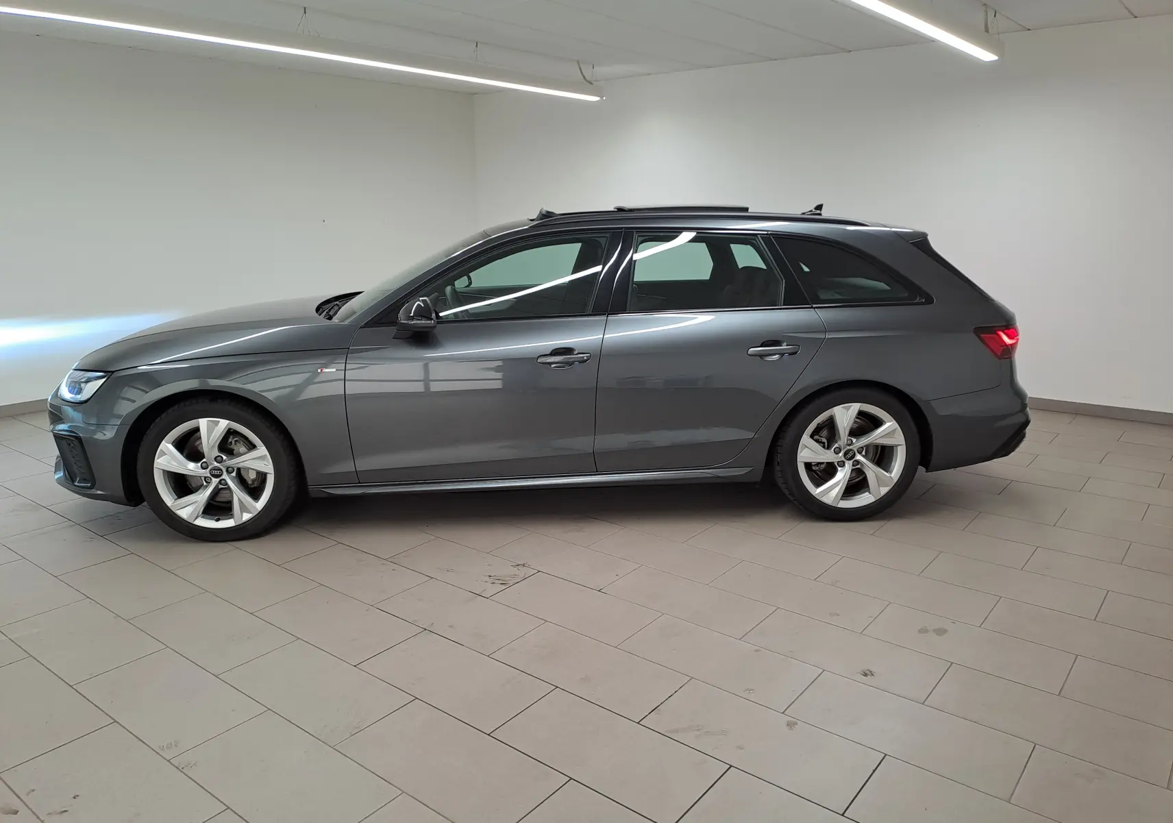 Audi A4 Avant 40 TDI gris Daytona vue de profil côté gauche, avec jantes 18 pouces et toit ouvrant panoramique.