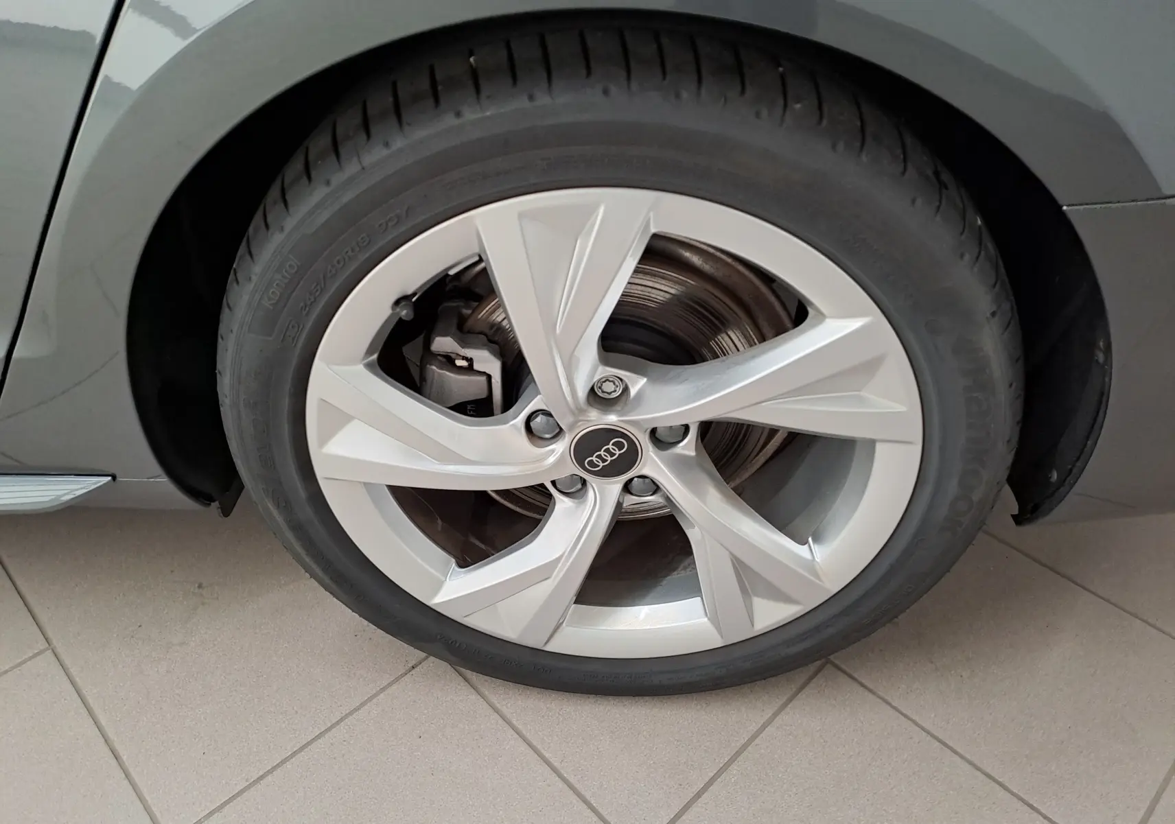 Gros plan sur la roue avant droite de l'Audi A4 Avant Gris Daytona avec jante alliage cinq branches.