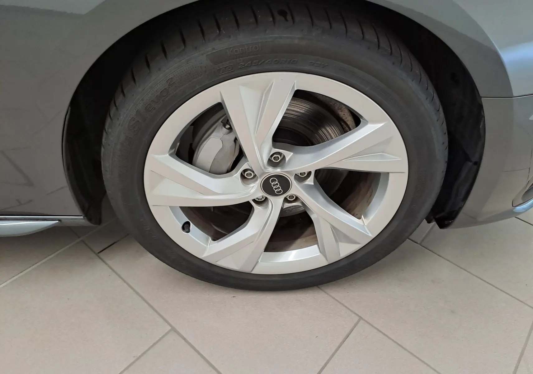 Gros plan sur la roue avant gauche de l'Audi A4 Avant 40 TDI gris Daytona avec jante alliage 18 pouces au design moderne.