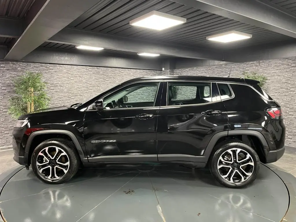 Profil côté gauche du Jeep Compass noir 2024 avec jantes alliage 18 pouces et logo visible sur la porte.