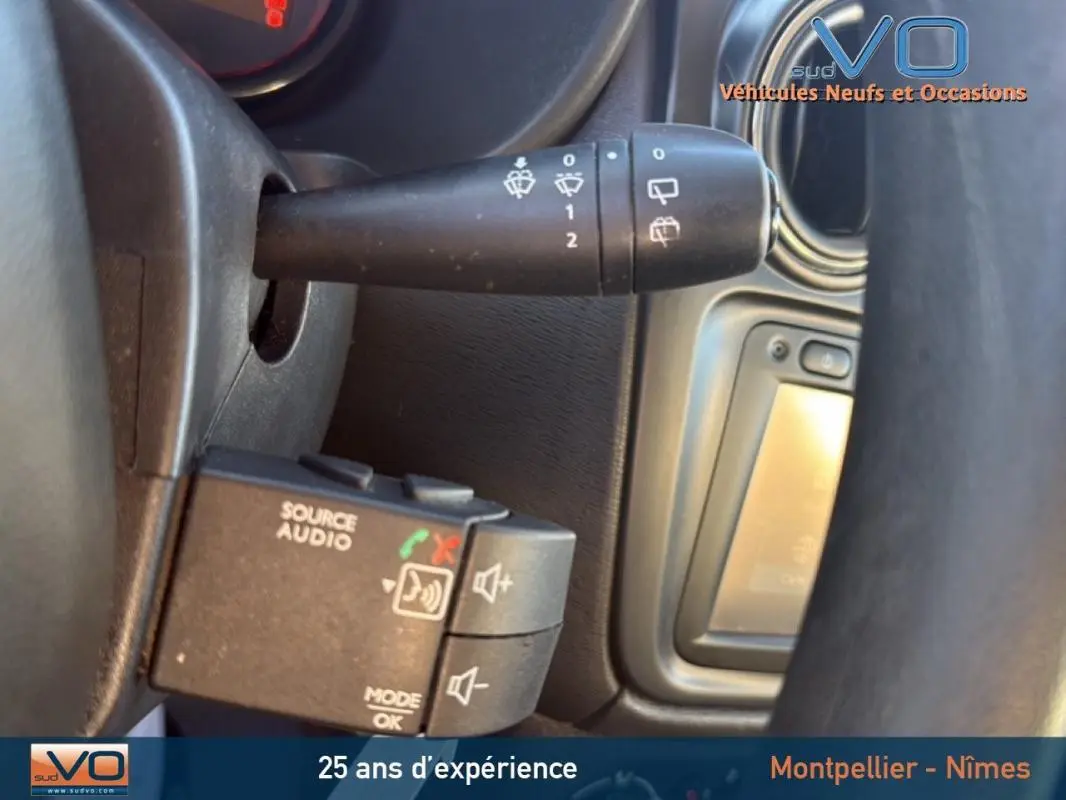 Gros plan sur la commande audio et essuie-glace du tableau de bord d'un Dacia Lodgy blanc 2018 GPL.