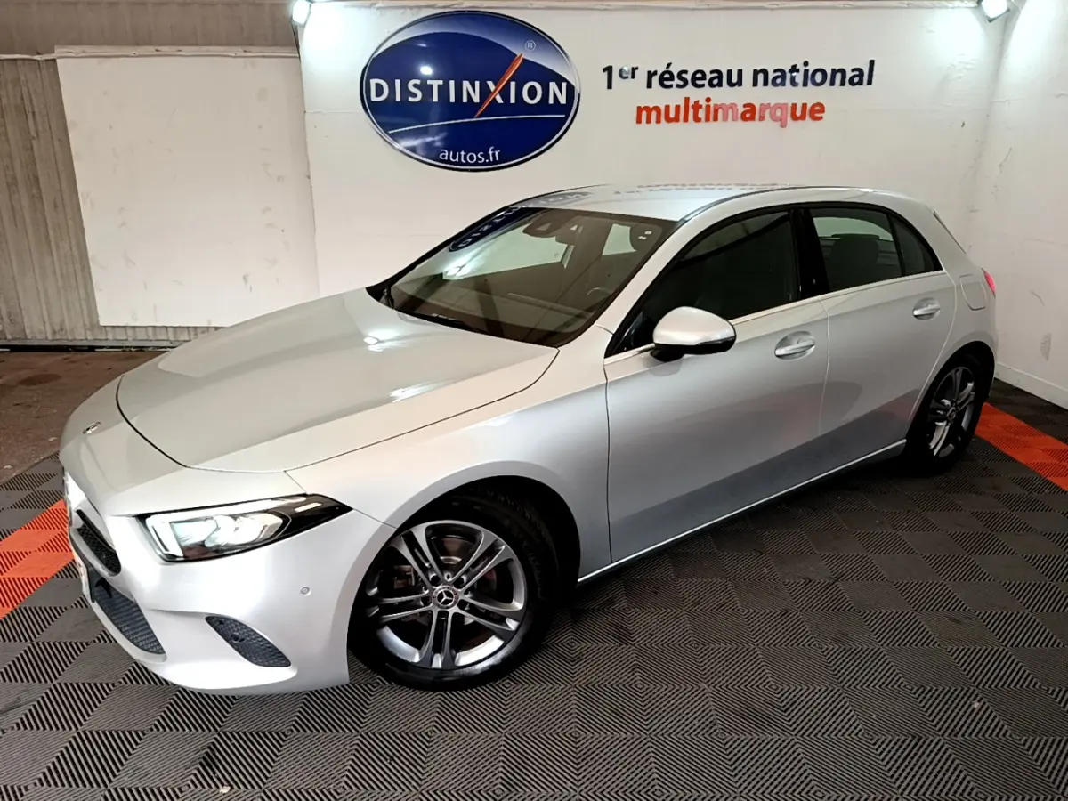 Vue 3/4 avant droit d'une Mercedes Classe A A 180 d Business Line gris clair dans un showroom intérieur.