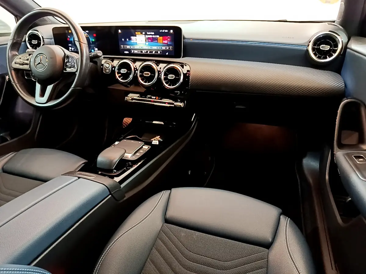 Intérieur de la Mercedes Classe A 180 d Business Line 2020, vue avant droite sur tableau de bord et sièges noirs.