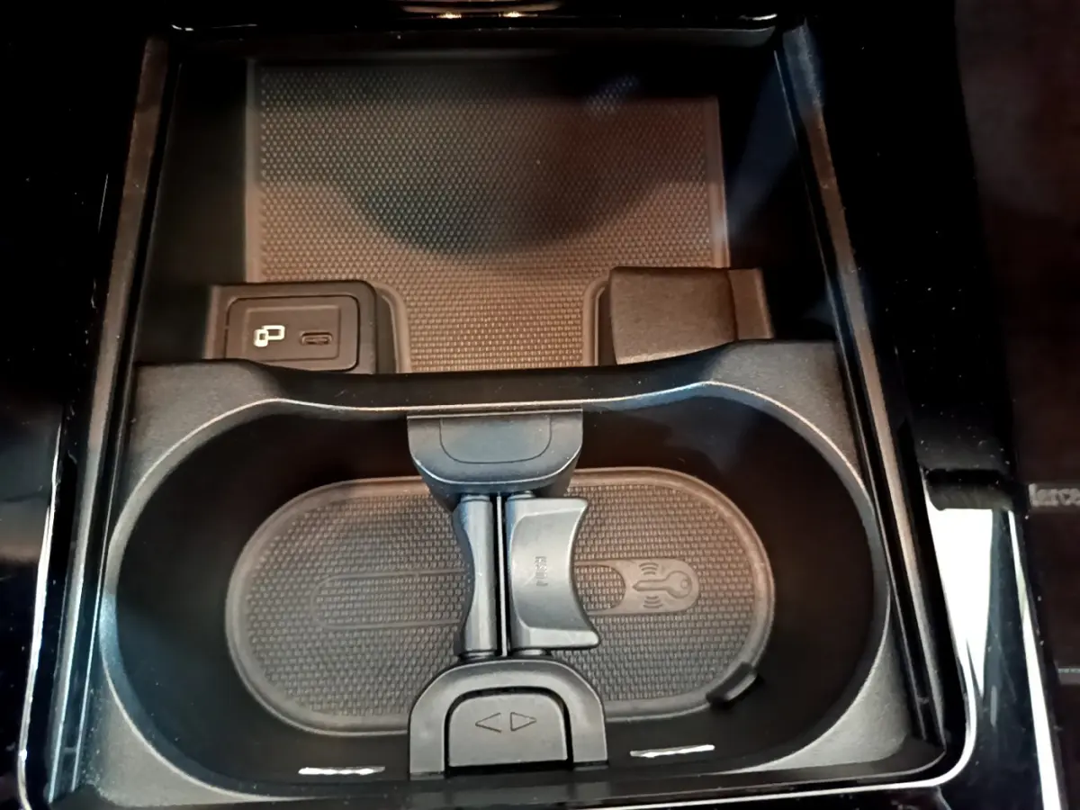 Gros plan sur le porte-gobelets central noir avec prise USB et finition brillante dans une Mercedes Classe A gris clair.