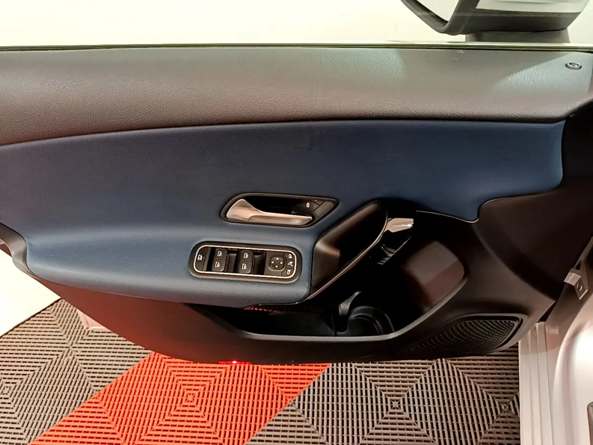 Vue rapprochée de la porte avant gauche gris clair de la Mercedes Classe A 180 d Business Line avec commandes électriques.