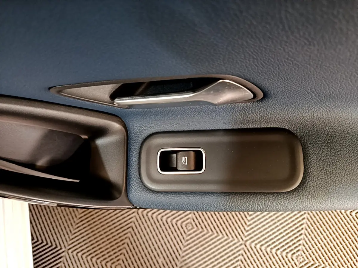 Gros plan sur la commande de lève-vitre côté conducteur dans l'habitacle gris foncé d'une Mercedes Classe A 180 d Business Line 2020.