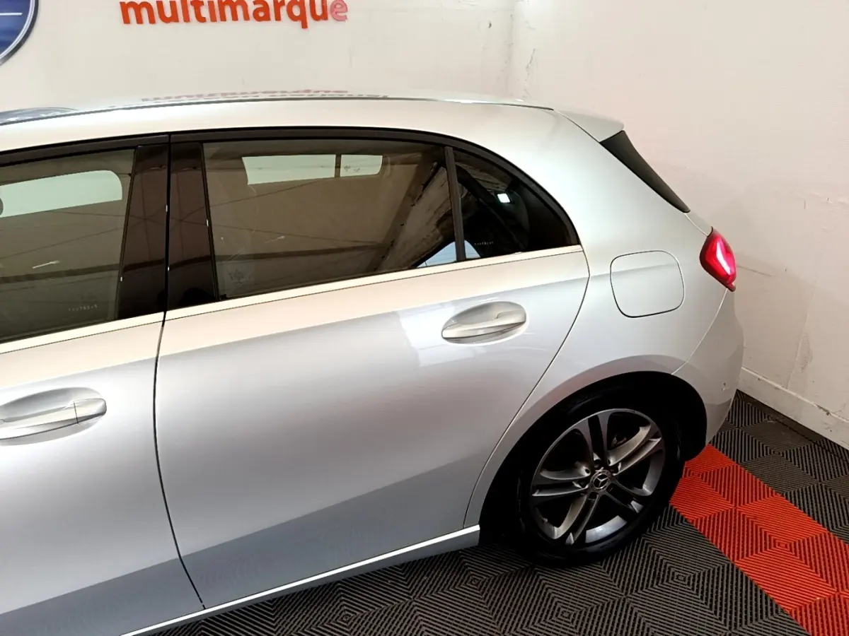 Vue latérale droite d'une Mercedes Classe A gris clair, mettant en valeur la porte arrière et la jante alliage sombre.