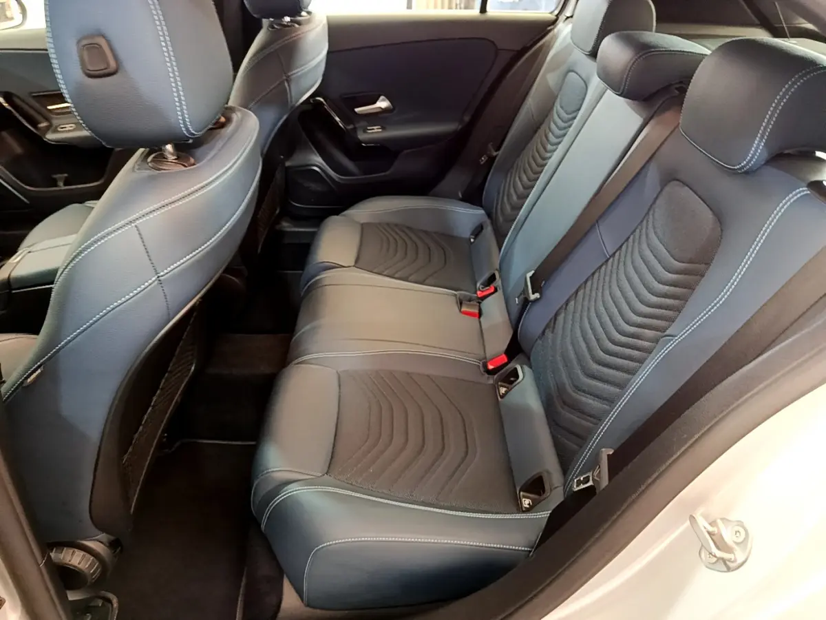 Vue intérieure côté droit montrant la banquette arrière noire avec surpiqûres blanches d'une Mercedes Classe A 180 d Business Line 2020.