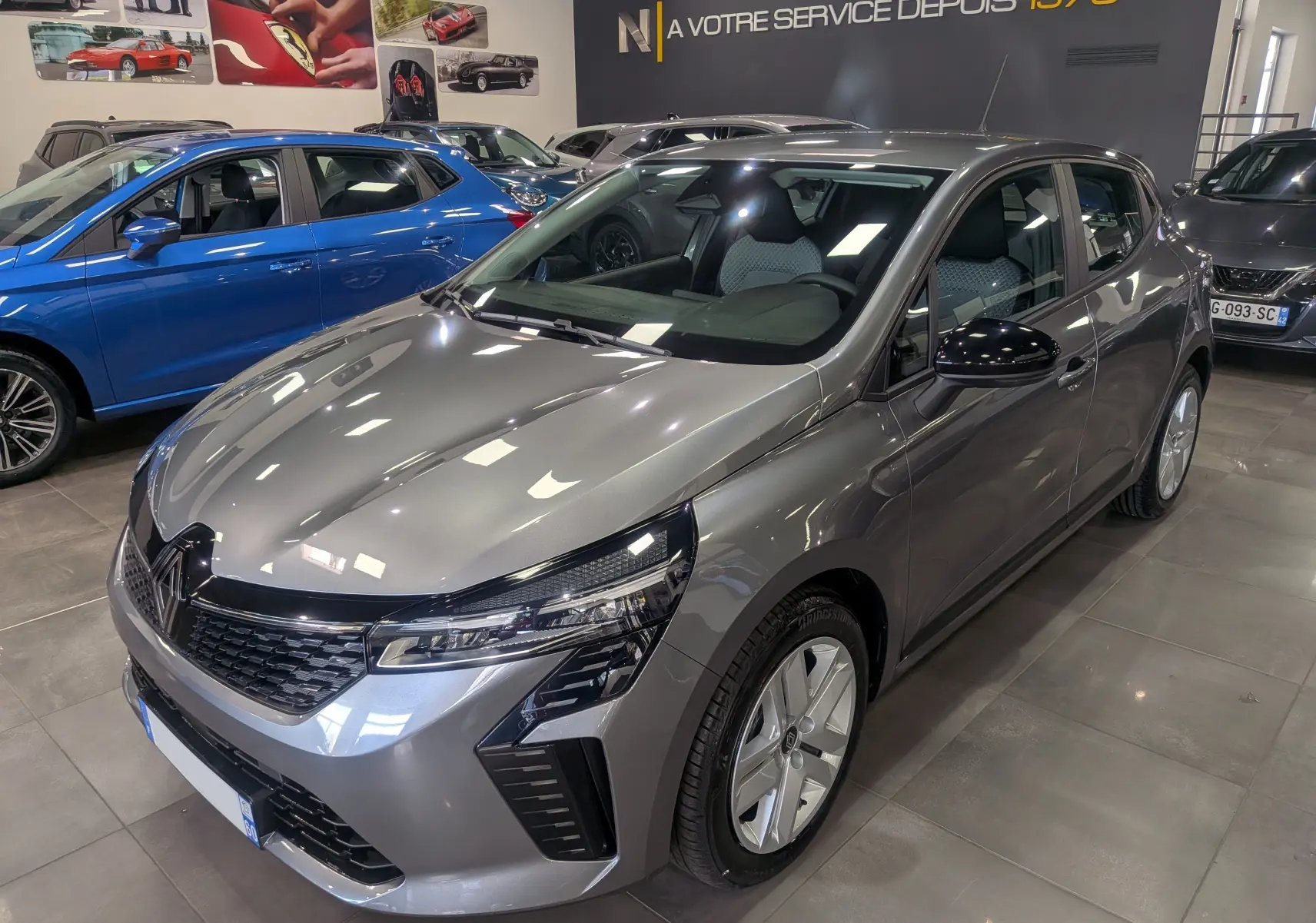 Renault Clio V Blue dCi 100 Evolution gris schiste vue 3/4 avant droit en intérieur showroom.