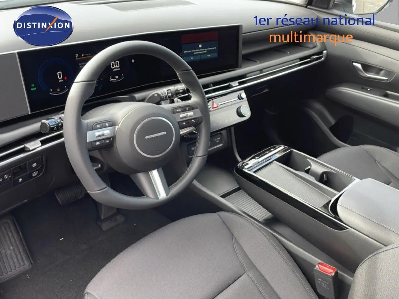 Vue intérieure côté conducteur du Hyundai Tucson 2026, avec tableau de bord numérique et finition tissu noir moderne.
