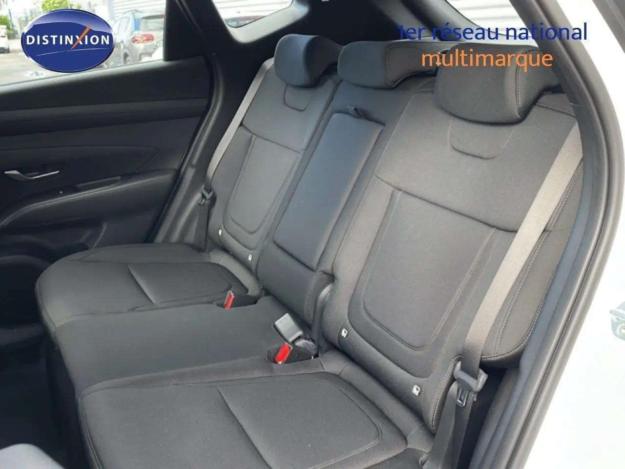 Vue intérieure côté droit des sièges arrière noirs en tissu du Hyundai Tucson blanc Atlas 2026, avec ceinture de sécurité visible.