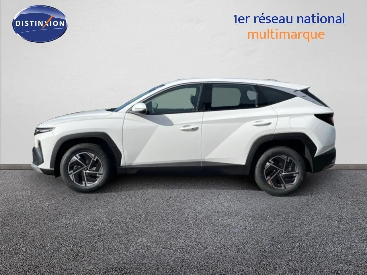 Vue de profil côté gauche d’un Hyundai Tucson blanc Atlas 2026 avec jantes alliage et lignes anguleuses marquées.