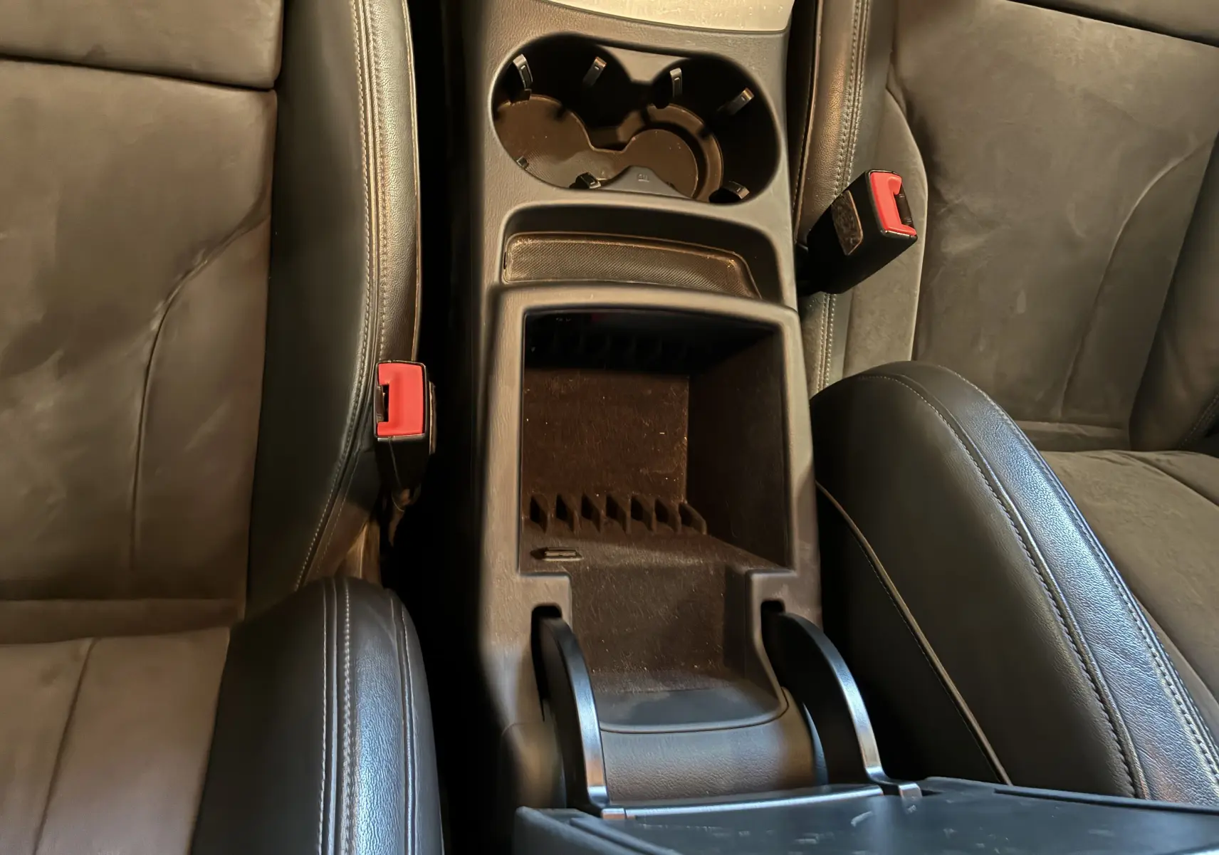 Vue rapprochée de la console centrale noire entre les sièges en cuir noir de l’Audi SQ5 2016.