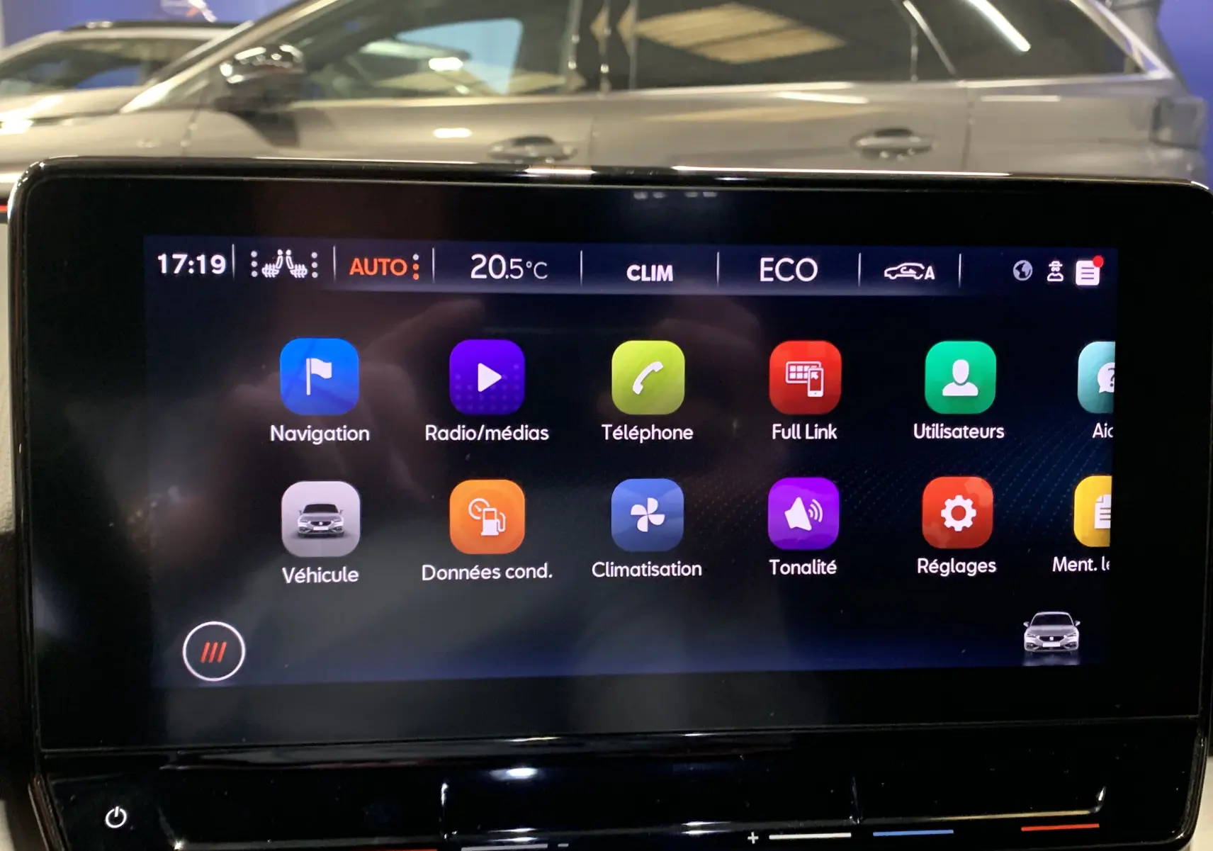 Écran tactile central affichant le menu multimédia d'une SEAT LEON gris, avec icônes colorées sur fond noir.
