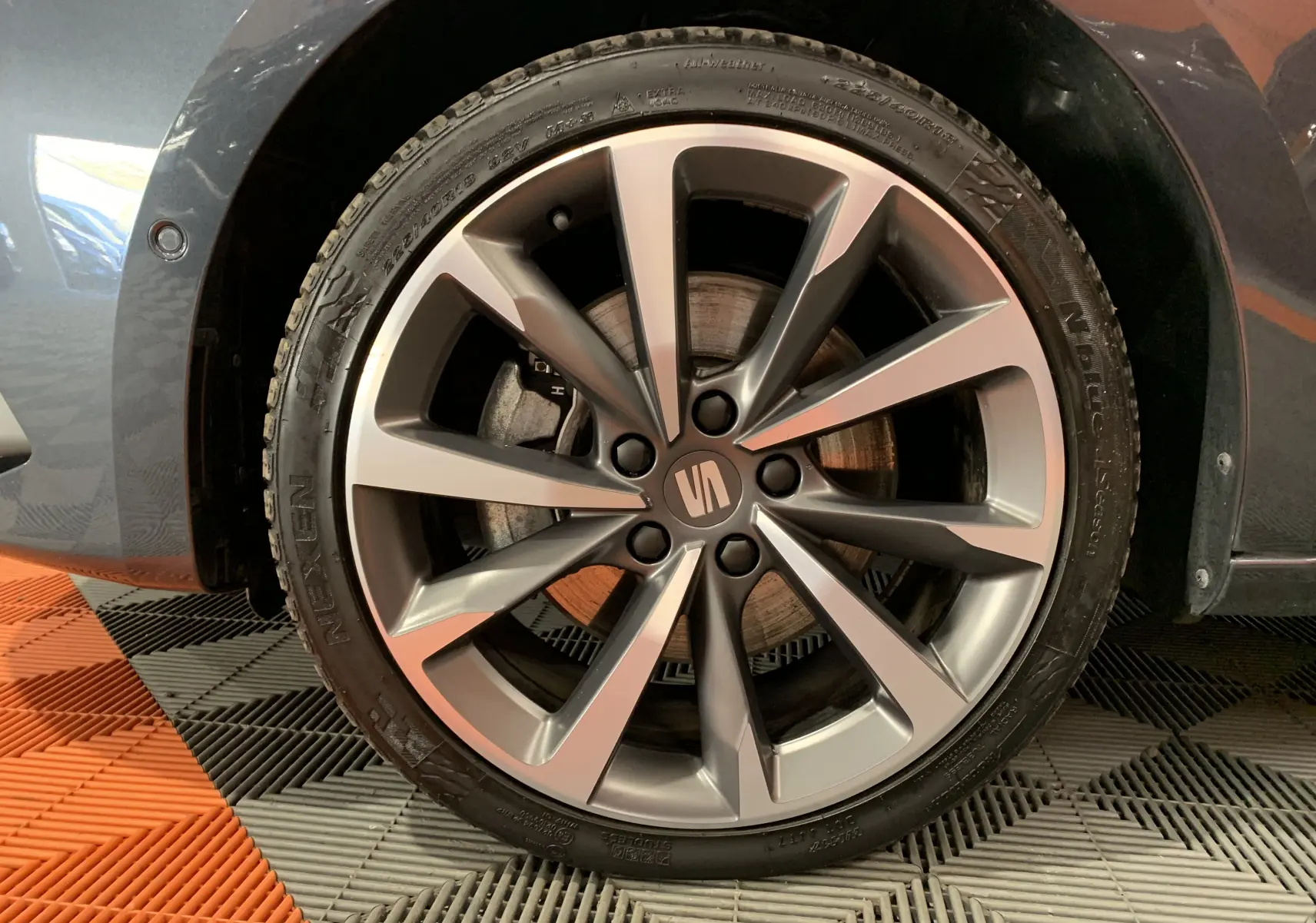 Gros plan sur la roue avant droite grise d'une SEAT LEON E-HYBRID 204 FR avec jante alliage à 5 doubles branches.
