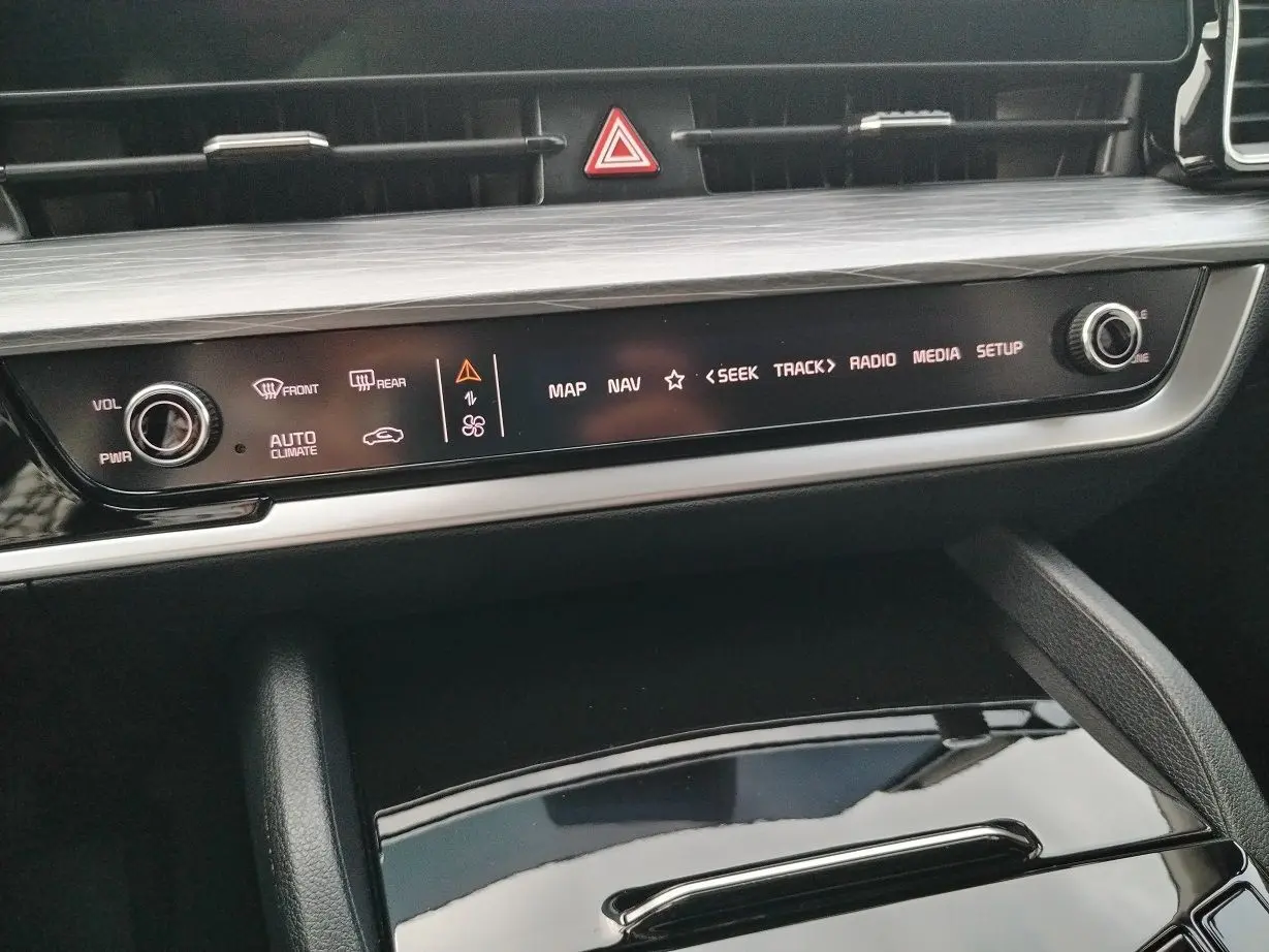 Détail de la console centrale du Kia Sportage gris perle 2025, avec commandes tactiles et bouton volume.