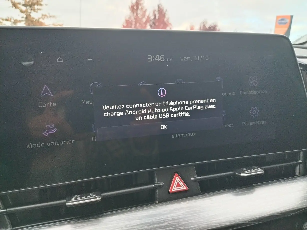 Écran tactile central du Kia Sportage 2025 affichant un message de connexion Android Auto/Apple CarPlay, intérieur noir.
