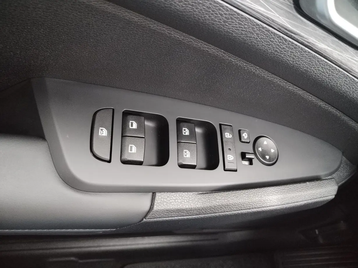 Gros plan sur la commande des vitres et rétroviseurs côté conducteur du Kia Sportage gris perle 2025.