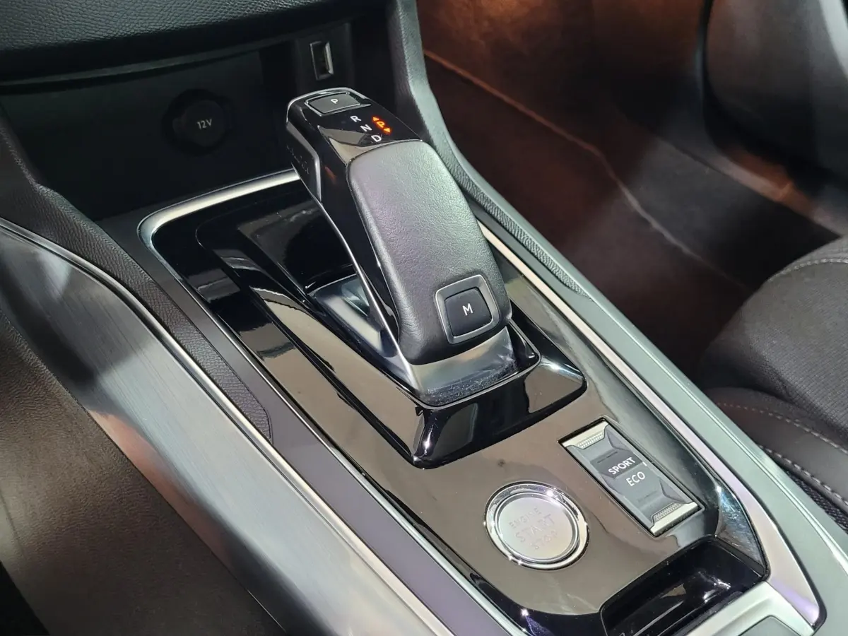 Gros plan sur la console centrale de la Peugeot 308 2020, boîte auto avec levier cuir et bouton démarrage.
