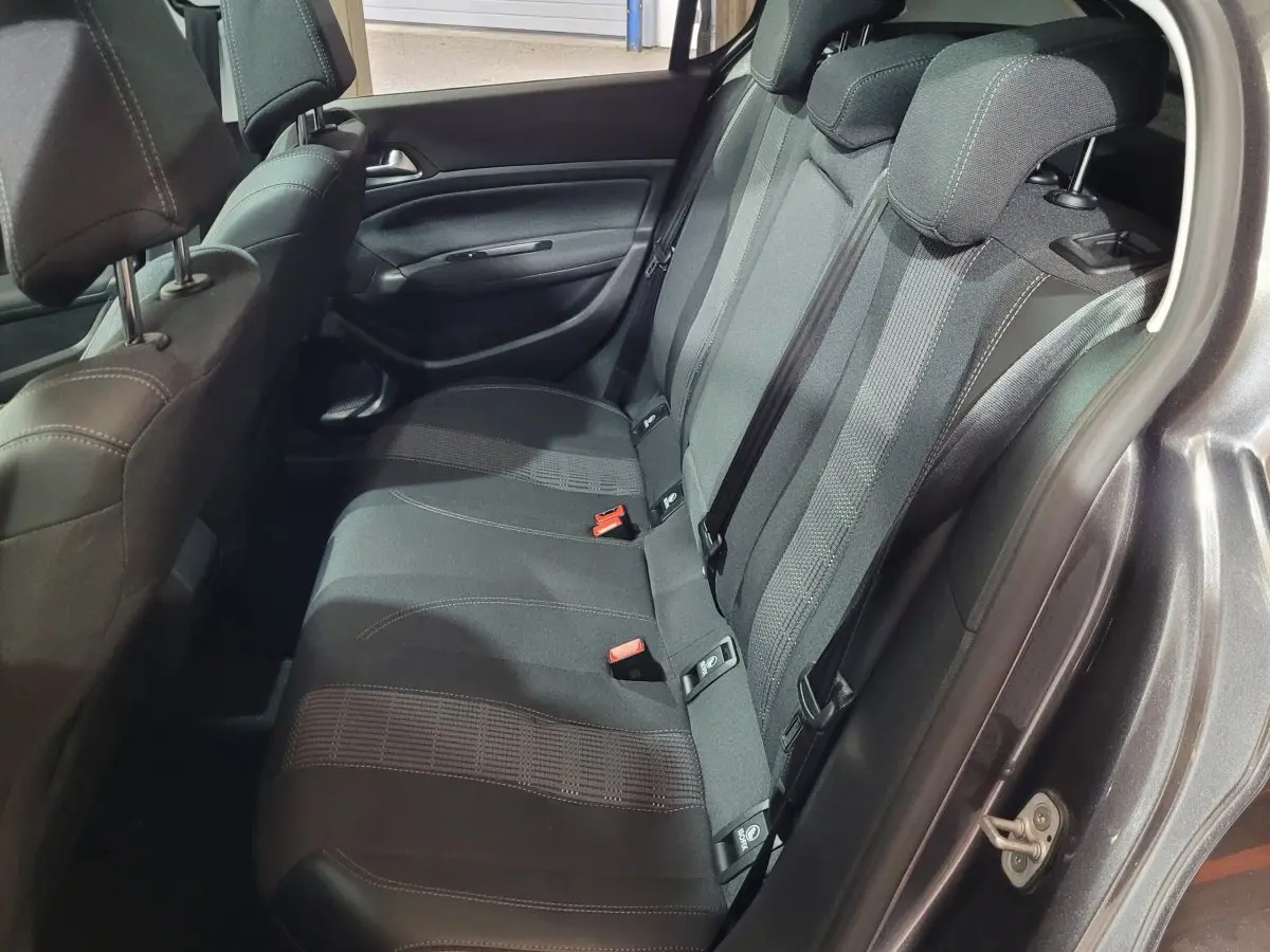 Vue côté droit de la banquette arrière gris foncé de la Peugeot 308 avec ceintures et appuie-têtes visibles.