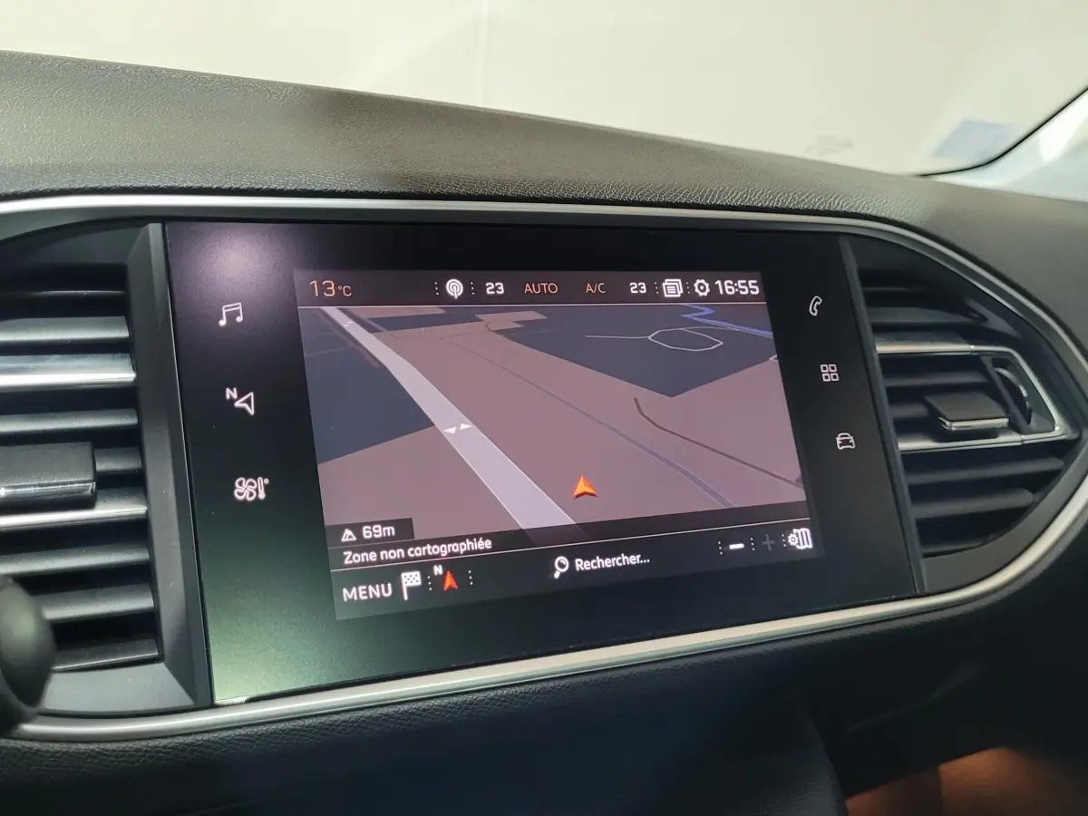 Écran tactile central du tableau de bord d'une Peugeot 308 gris foncé, affichant la navigation GPS.