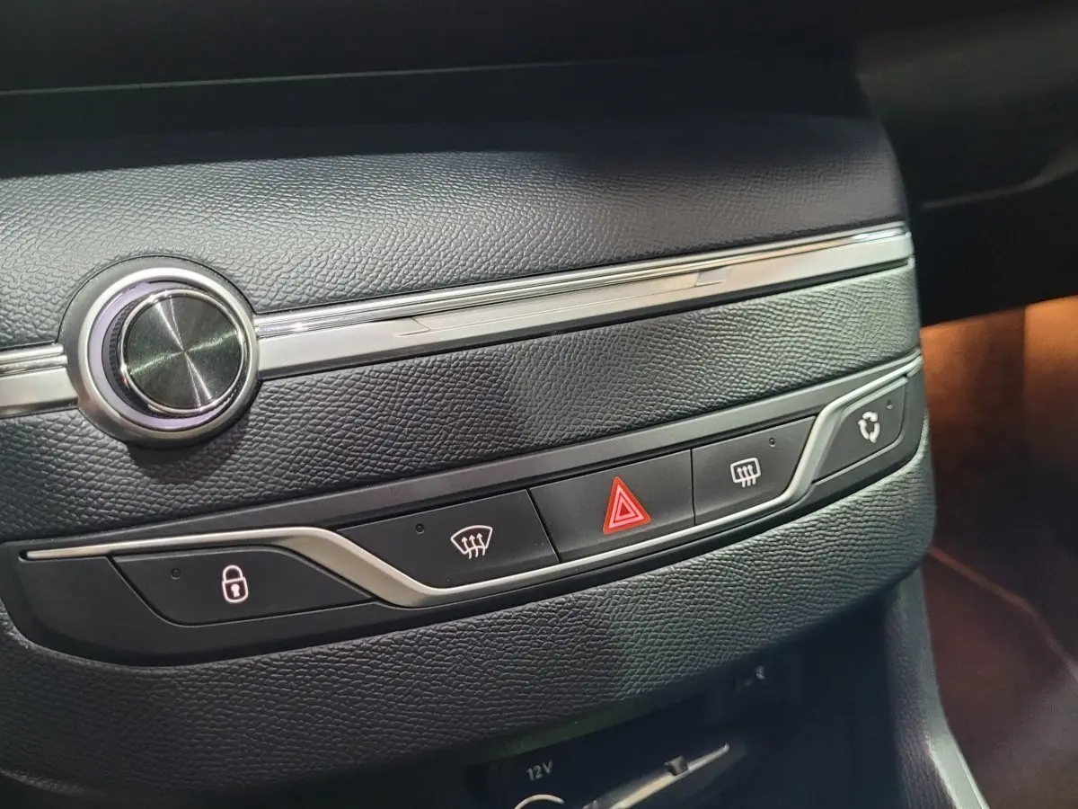 Gros plan sur la console centrale en cuir noir de la Peugeot 308 gris foncé, avec boutons de verrouillage et warning.