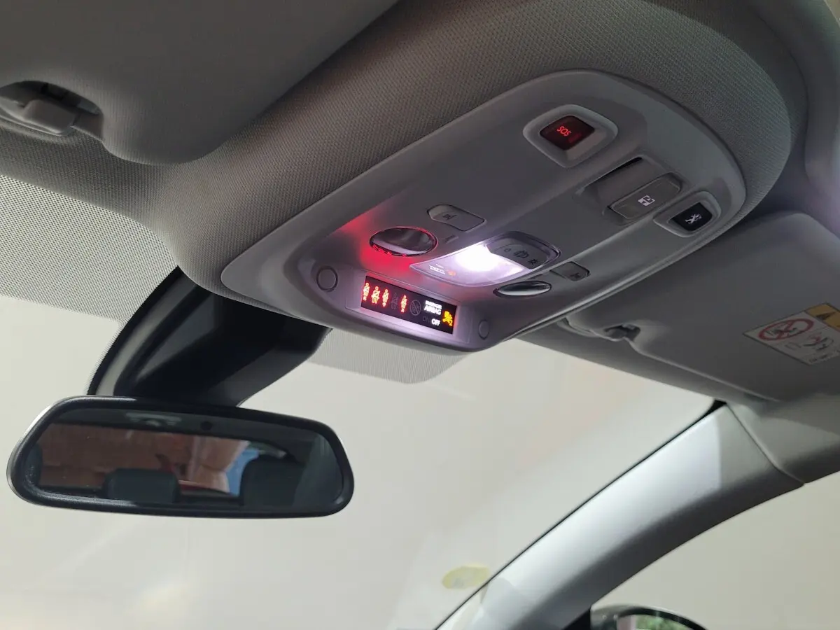 Plafonnier allumé avec commandes et rétroviseur intérieur dans l'habitacle gris clair de la Peugeot 308 2020.