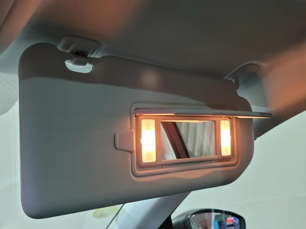 Miroir de courtoisie éclairé sur pare-soleil côté conducteur dans l'habitacle d'une Peugeot 308 gris foncé 2020.