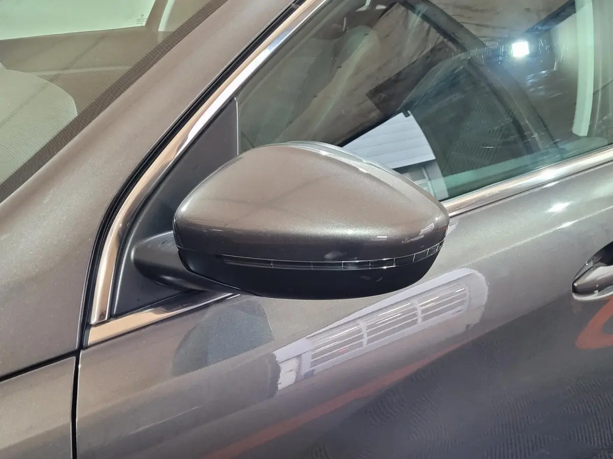 Rétroviseur côté gauche gris foncé de la Peugeot 308 BlueHDi 130 vue en gros plan sur la portière avant.