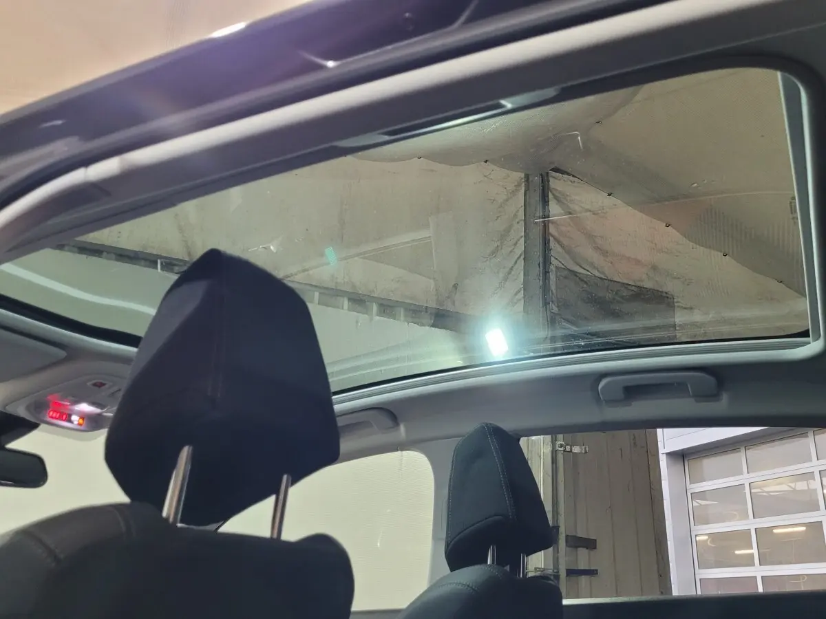 Toit panoramique ouvert vu de l'intérieur arrière avec appuie-têtes noirs sur PEUGEOT 308 gris foncé