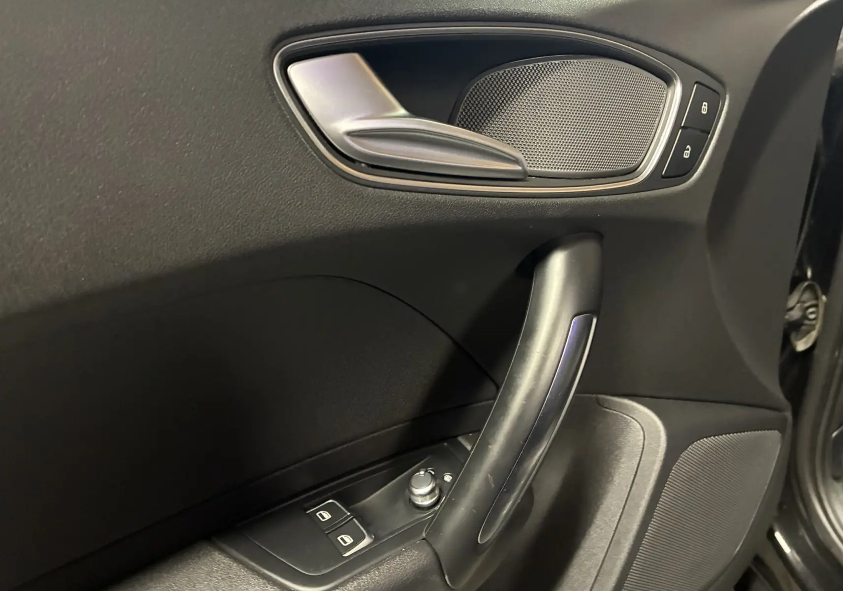 Gros plan sur la poignée intérieure côté gauche de la porte noire d'une Audi A1 1.0 TFSI S-Line de 2016.