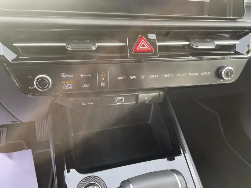 Vue rapprochée de la console centrale du Kia Niro 2024 bleu métal, montrant les commandes tactiles et la ventilation.